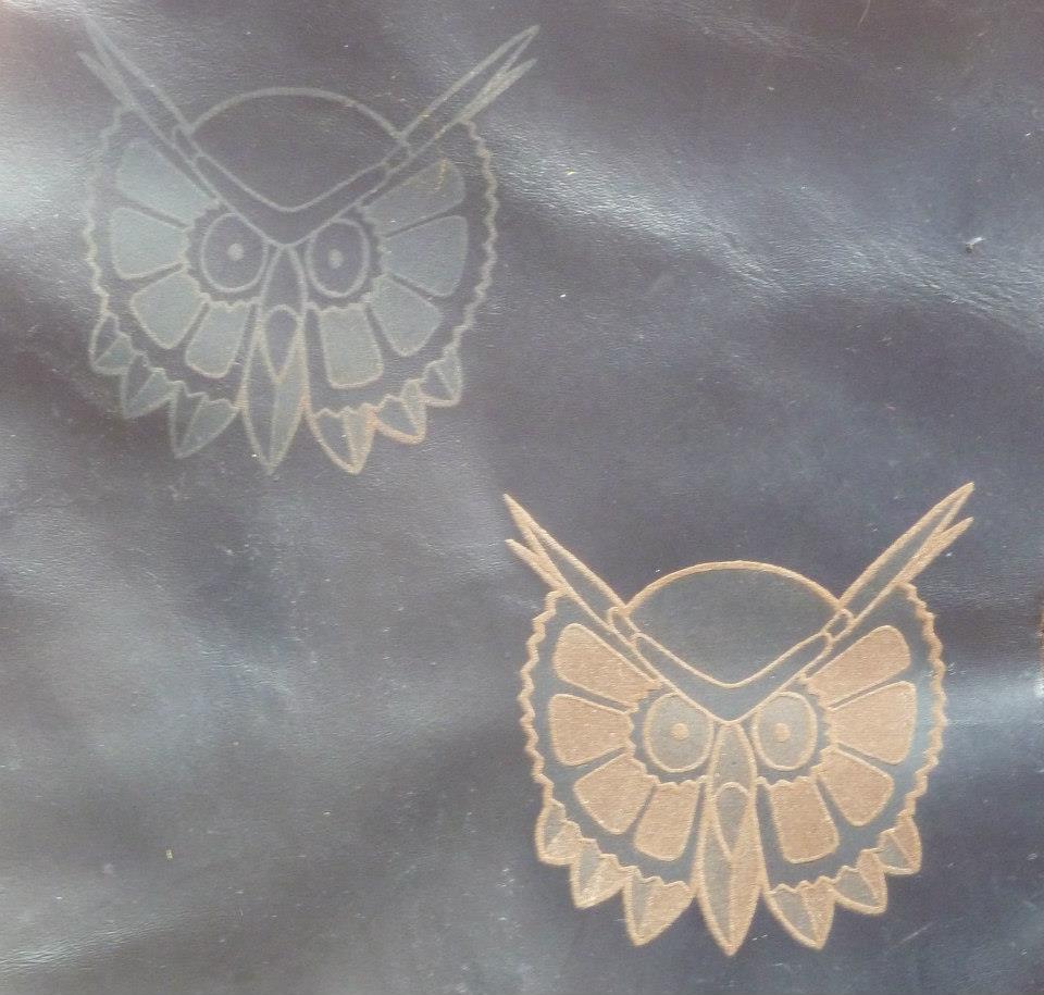 Engraved owl heads on leather